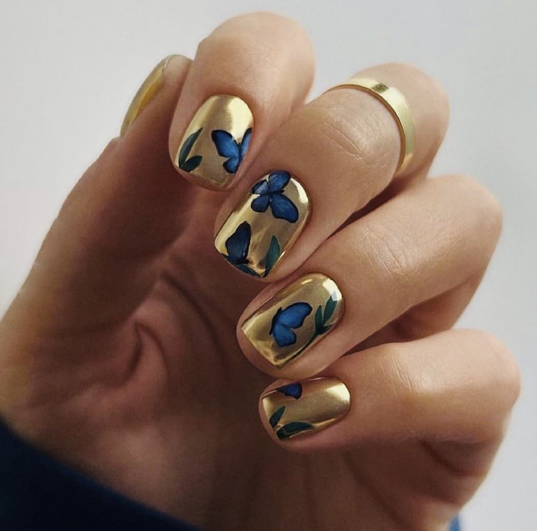 Gold chrome nails with blue butterfly art